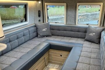 Una furgoneta cámper funcional con un gran salón convertible en dormitorio y vistas a tres vientos